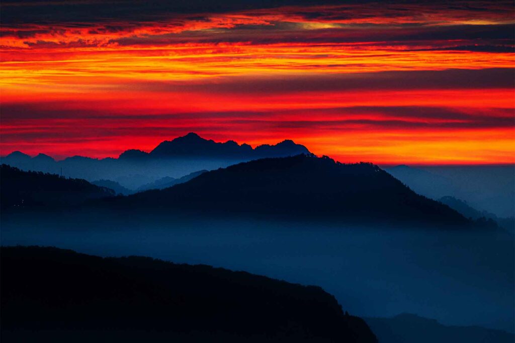 Photo of a rainbow sky over the mountains showing the sky is the limit!